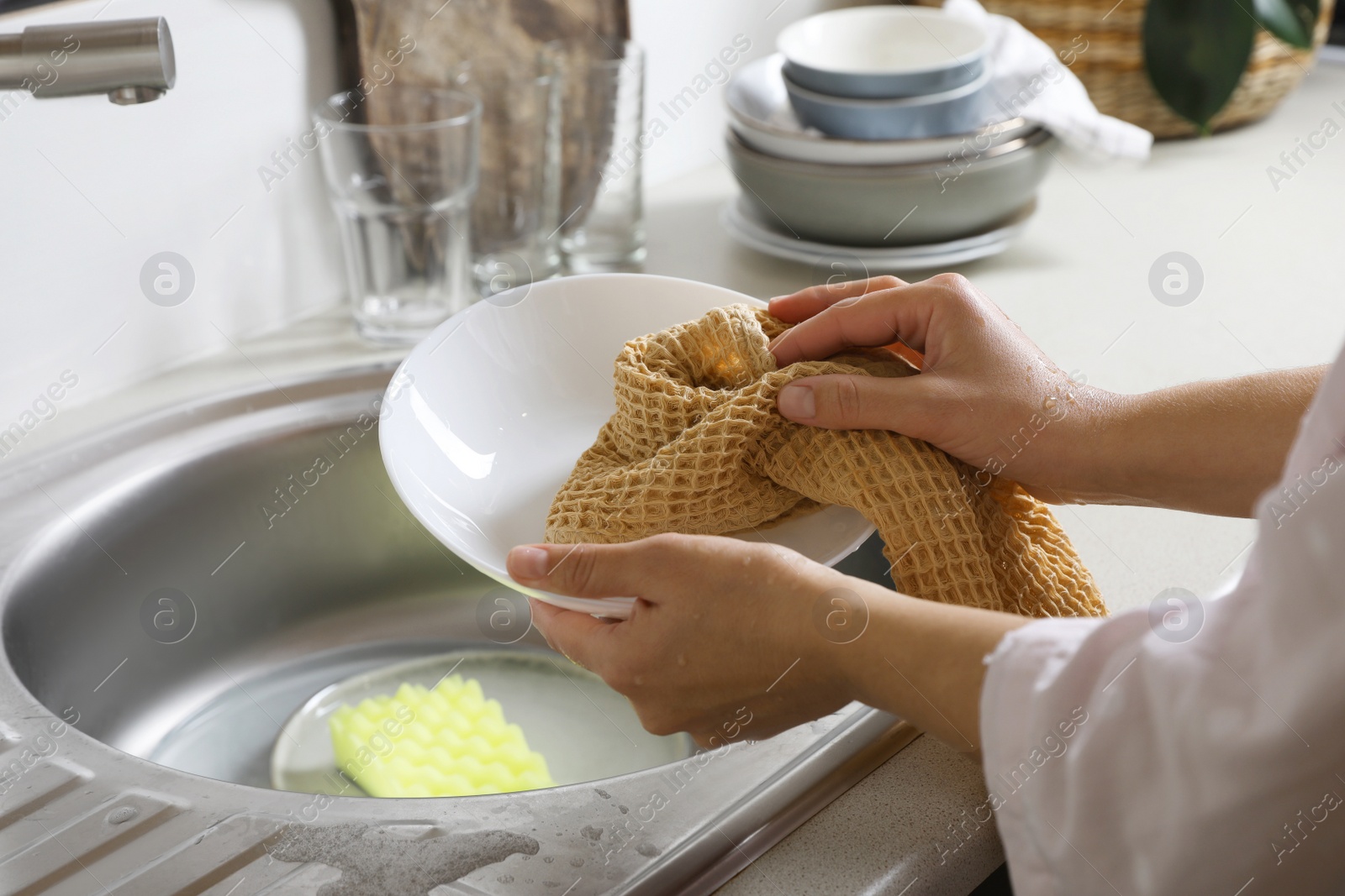 Photo of Woman wiping plate with towel in kitchen , closeup