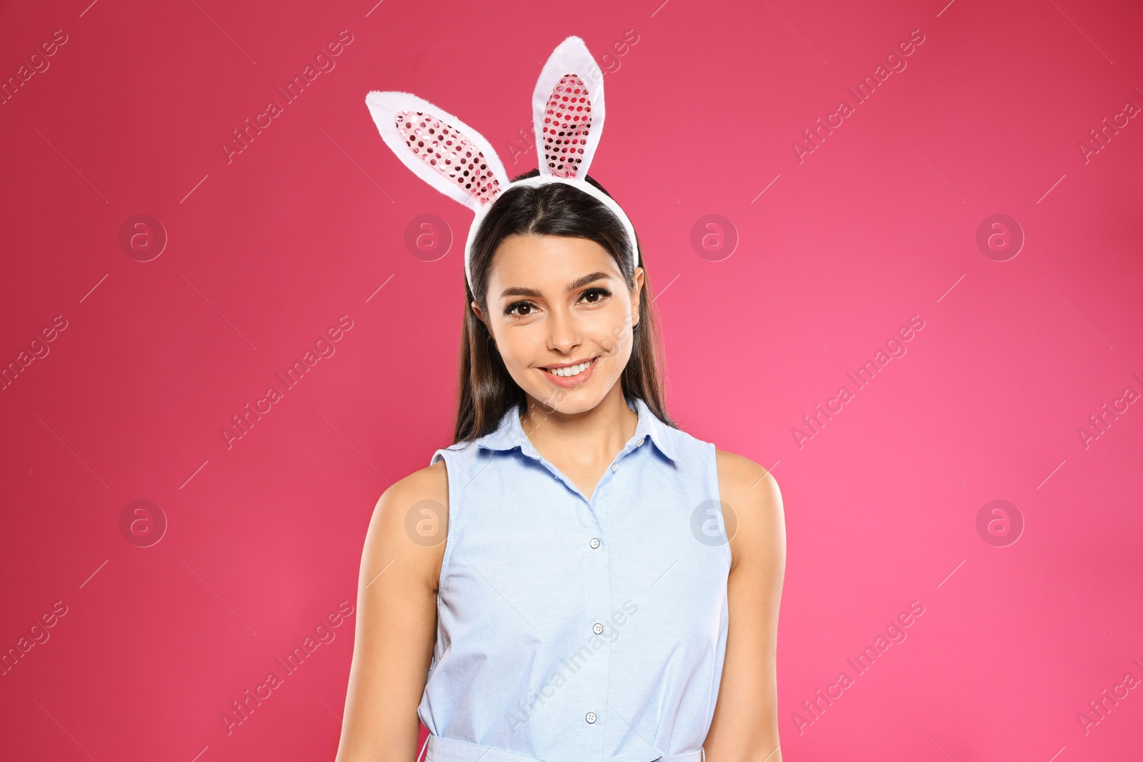 Photo of Portrait of beautiful woman in Easter bunny ears headband on color background