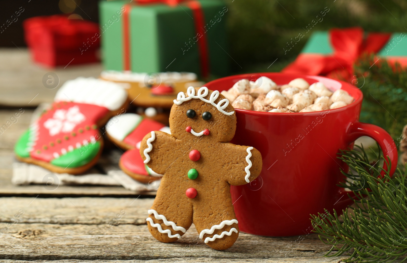 Photo of Tasty gingerbread man cookie and cocoa with marshmallows on wooden table. Space for text