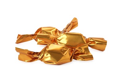 Delicious candies in golden wrappers on white background