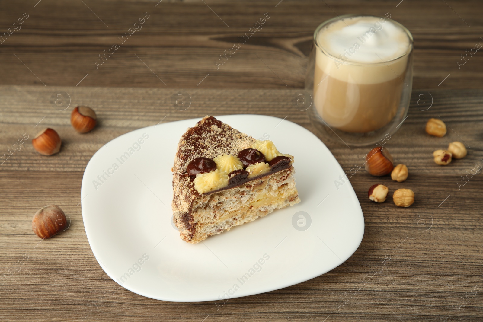 Photo of Piece of delicious Kyiv Cake served with coffee on wooden table, selective focus