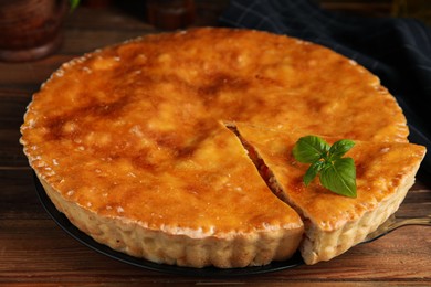 Delicious pie with meat and basil on wooden table