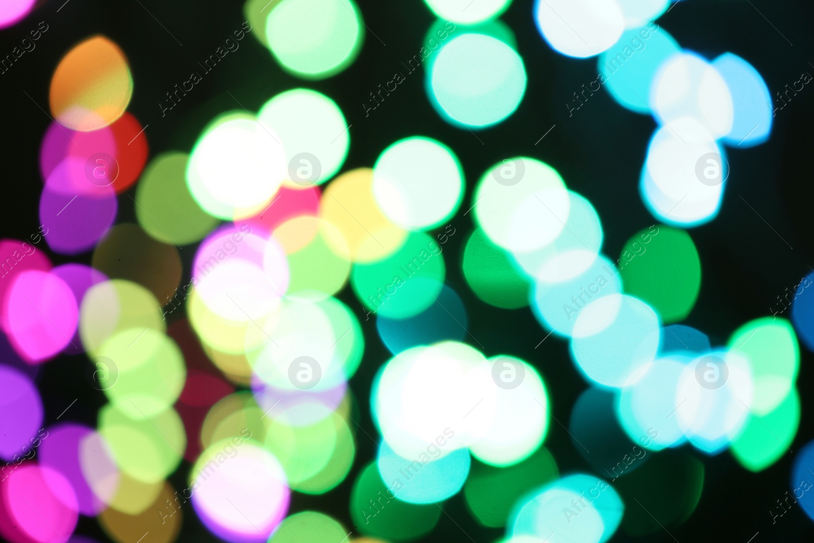 Photo of Blurred view of colorful lights on black background. Bokeh effect