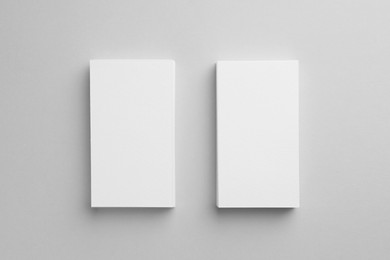 Blank business cards on light gray background, top view. Mockup for design