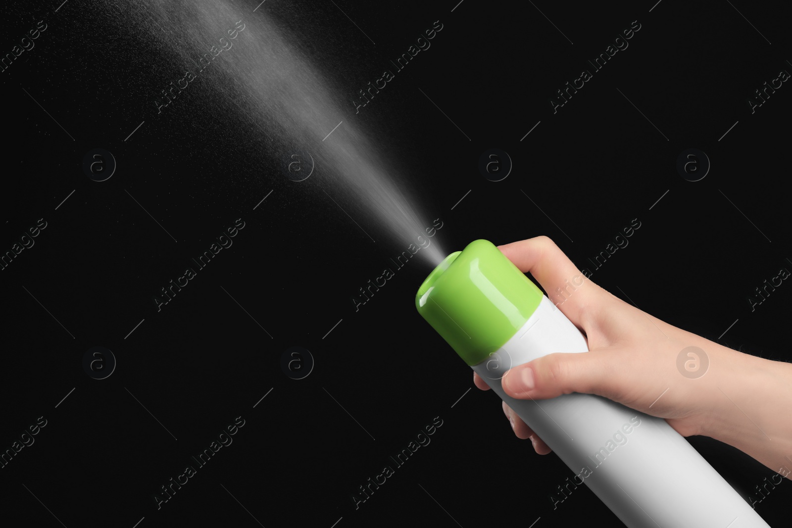 Photo of Woman spraying air freshener on black background, closeup