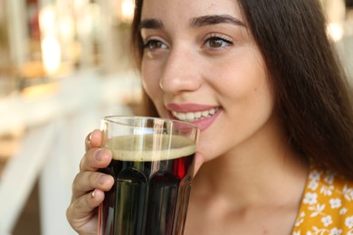 Photo of Beautiful woman with cold kvass outdoors, closeup. Traditional Russian summer drink