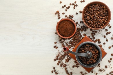 Vintage manual coffee grinder with beans and powder on white wooden table, flat lay. Space for text