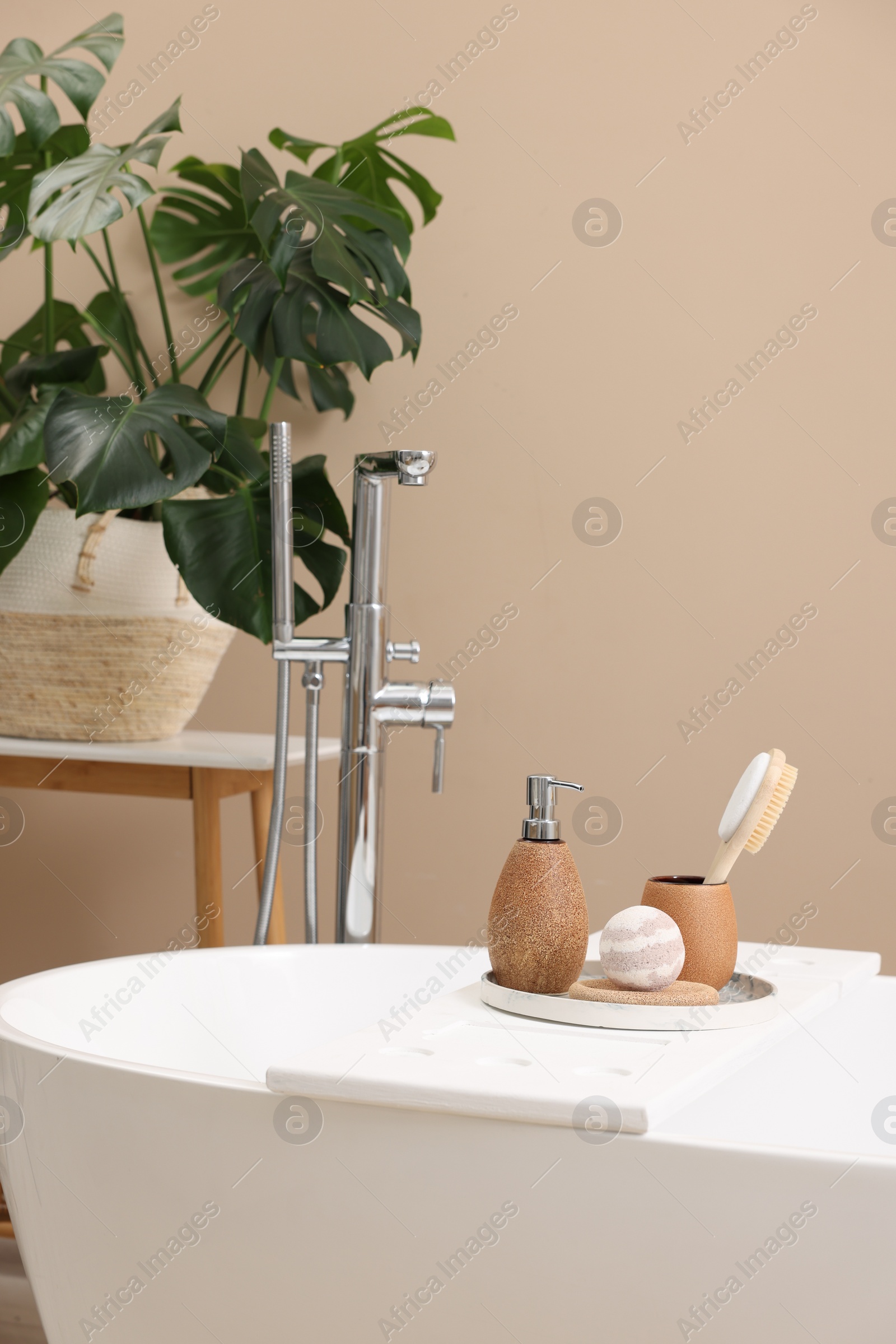 Photo of Different personal care products and accessories on bath tub in bathroom