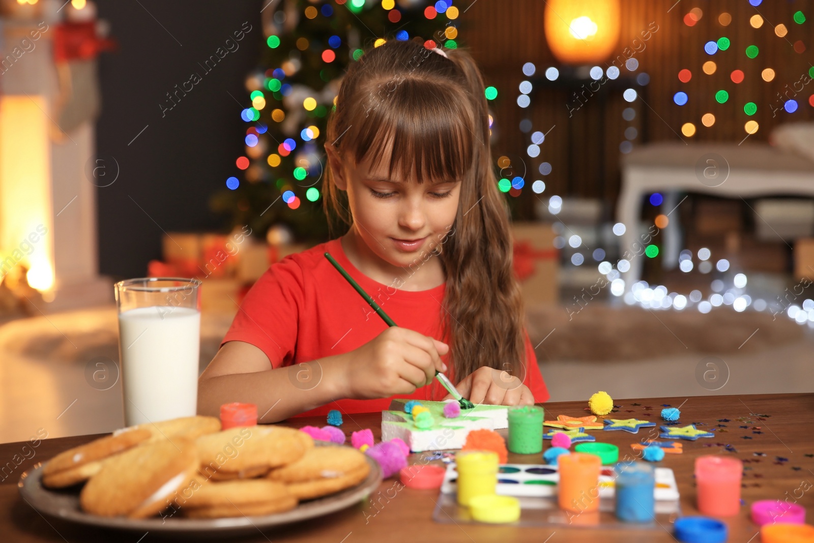 Photo of Little child painting Christmas tree of foam plastic at home