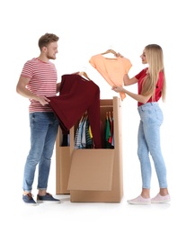 Photo of Young couple near wardrobe boxes on white background