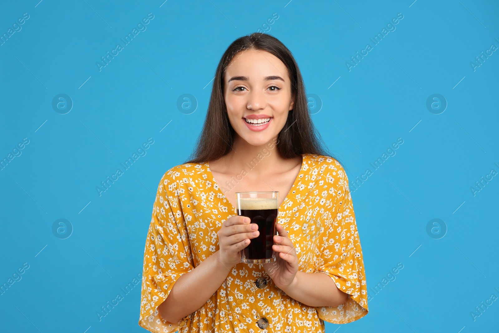 Photo of Beautiful woman with cold kvass on blue background. Traditional Russian summer drink