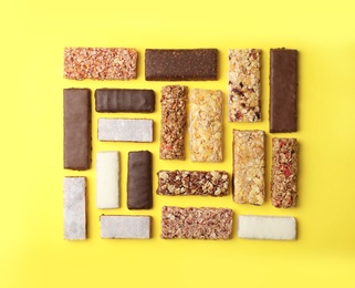 Photo of Flat lay composition with protein bars on color background