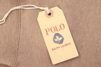 Photo of Leiden, Netherlands - December 6, 2023: Polo Ralph Lauren clothing tag on brown garment, top view