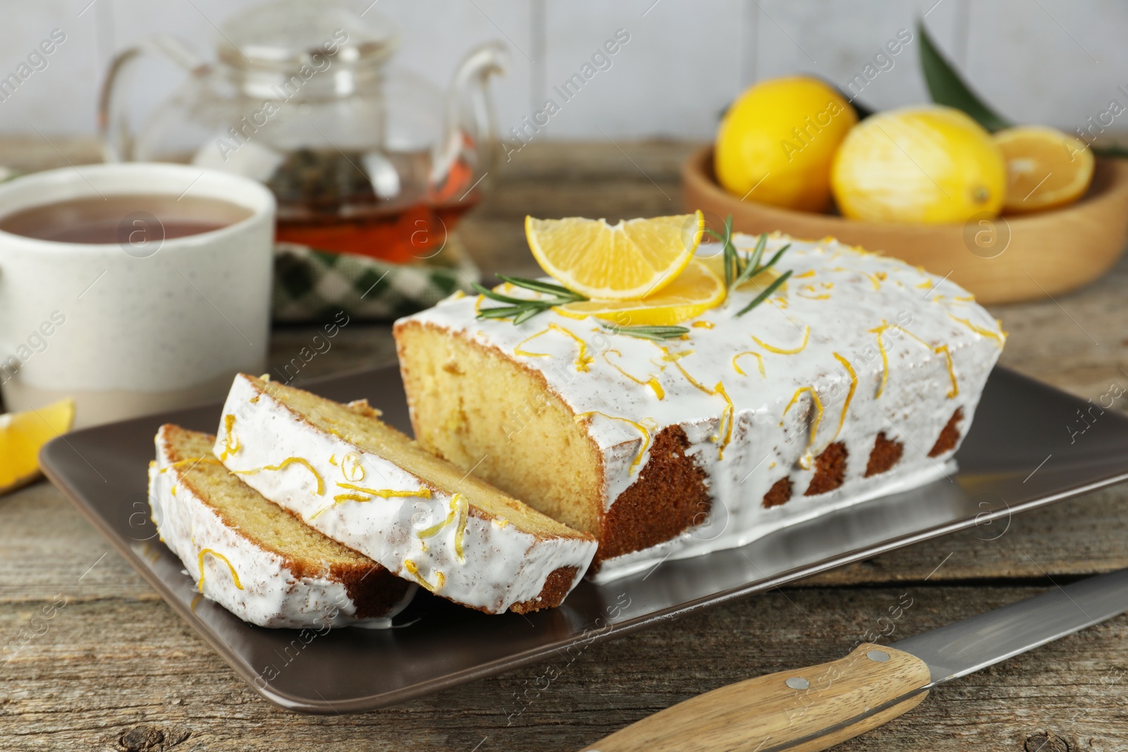 Photo of Tasty lemon cake with glaze on wooden table, closeup