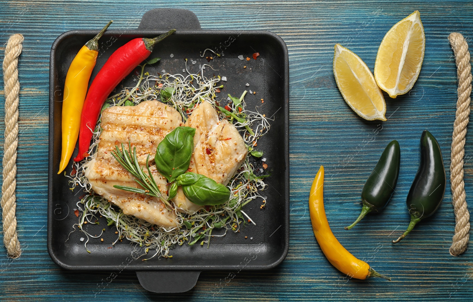 Photo of Flat lay composition with grilled fish on blue wooden table