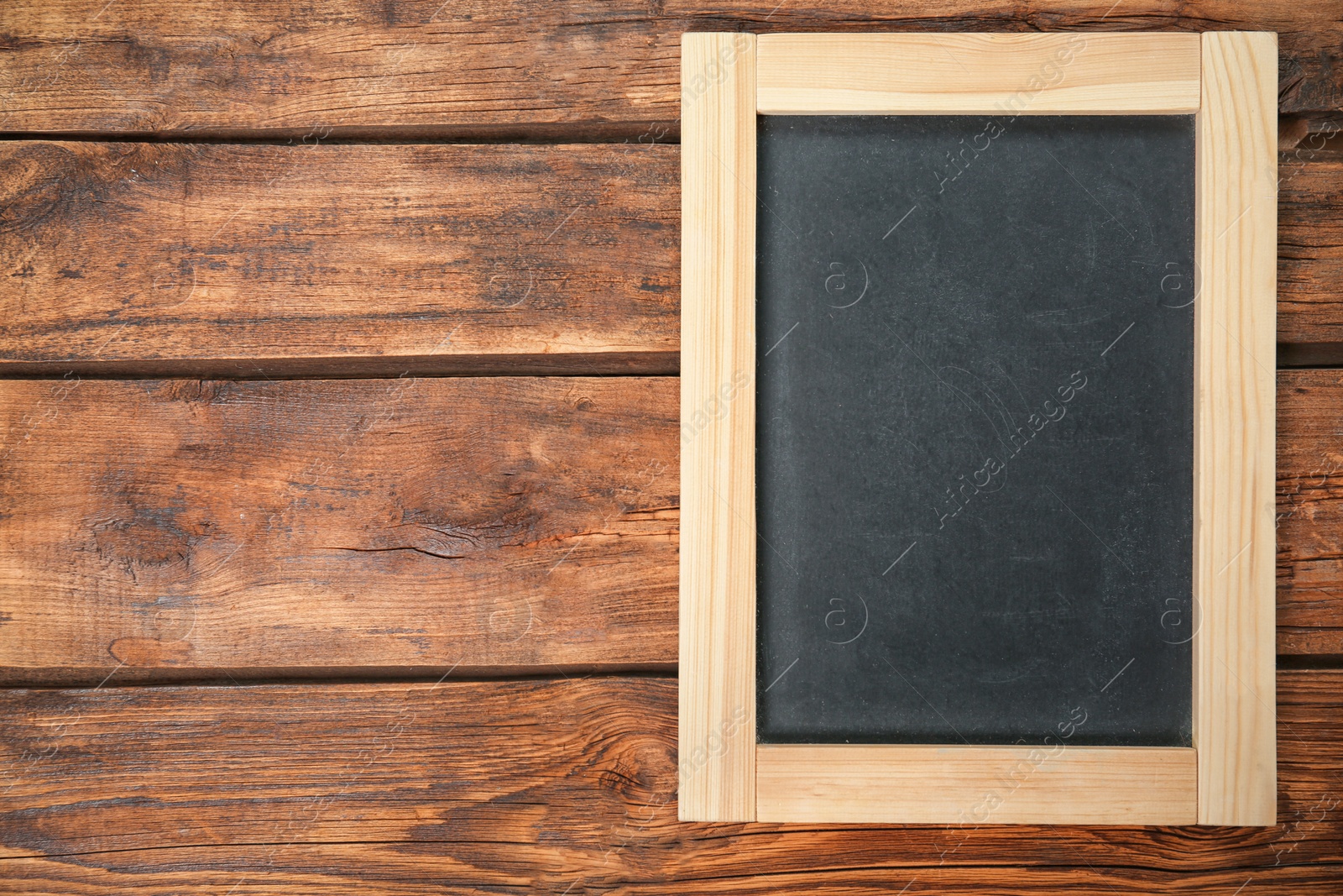 Photo of Empty clean chalkboard on wooden background