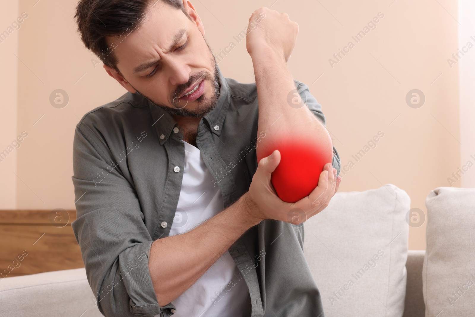 Image of Man suffering from rheumatism in elbow at home