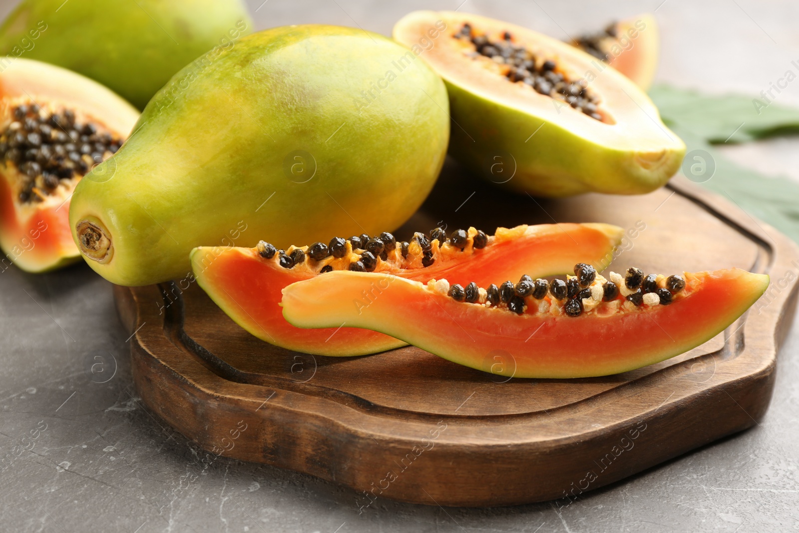 Photo of Fresh ripe papaya fruits on grey table