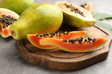 Fresh ripe papaya fruits on grey table