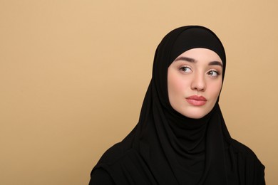 Photo of Portrait of Muslim woman in hijab on beige background, space for text