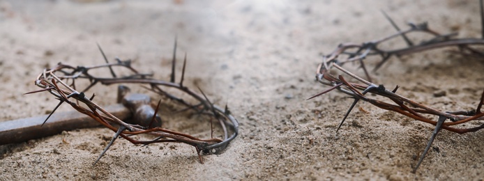 Passion Of Jesus Christ. Crowns of thorns and hammer on sand, banner design