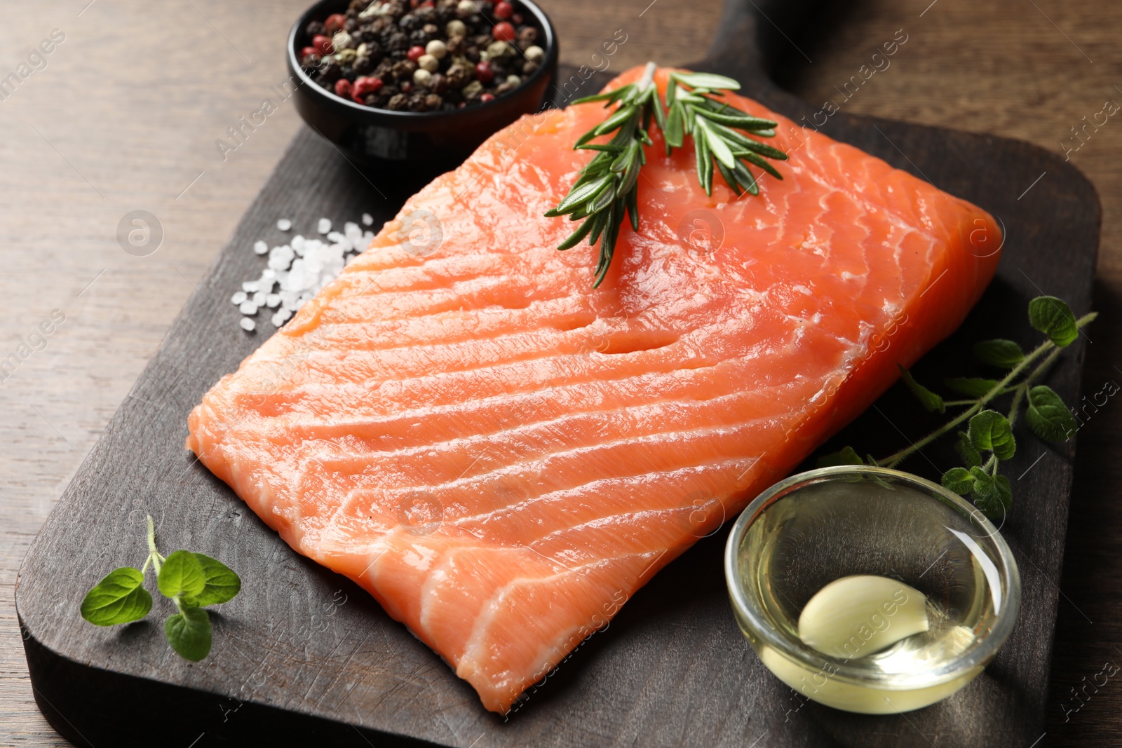 Photo of Fresh raw salmon and ingredients for marinade on wooden table, closeup