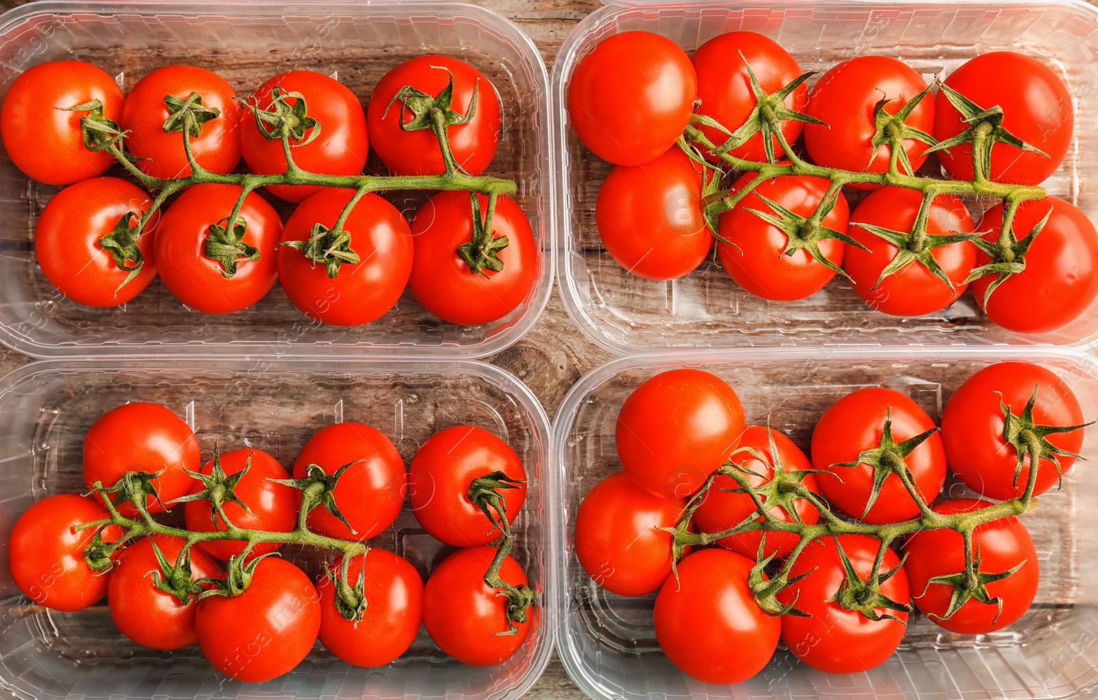 Photo of Fresh ripe tomatoes in plastic containers, top view