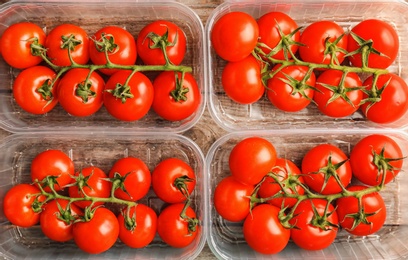 Photo of Fresh ripe tomatoes in plastic containers, top view