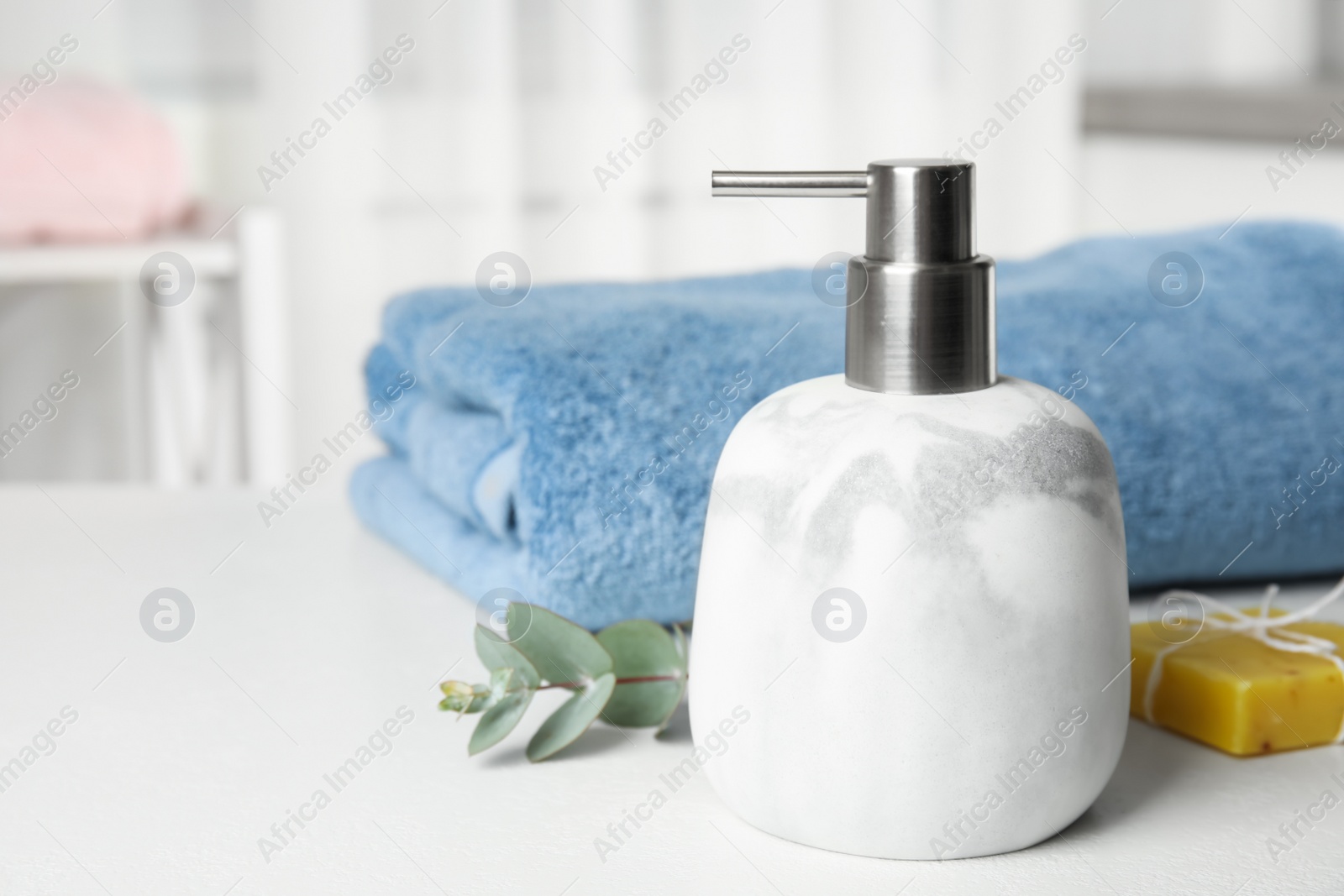 Photo of Marble dispenser, eucalyptus and soap bar on white table