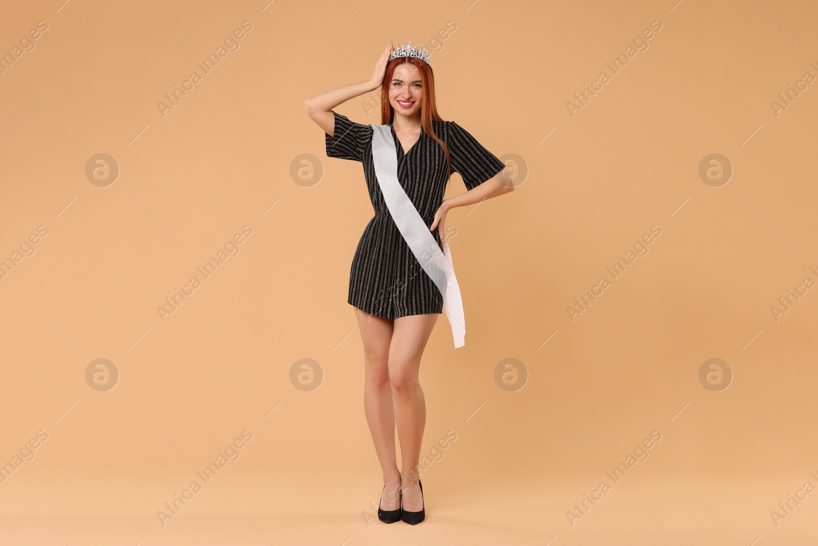 Photo of Beautiful young woman with tiara in dress on beige background