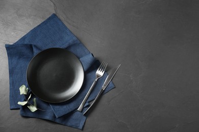 Photo of Stylish setting with elegant cutlery on grey textured table, top view. Space for text