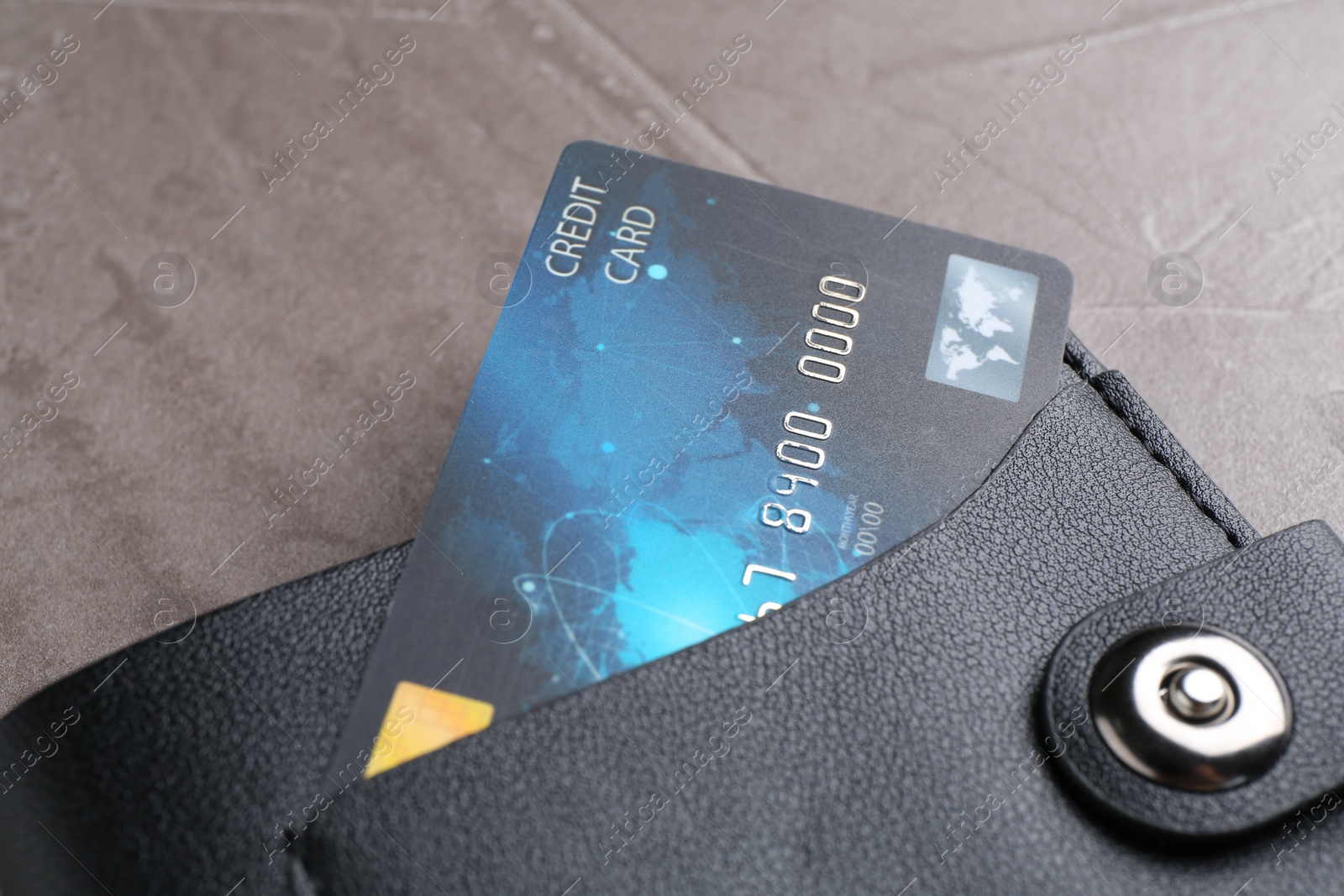 Photo of Credit card in leather wallet on grey textured table, closeup