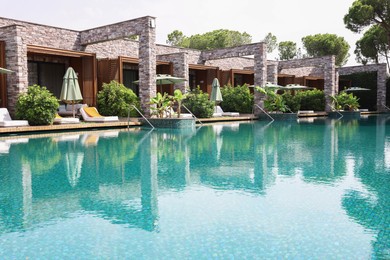 Photo of Outdoor swimming pool with umbrellas and sunbeds at resort