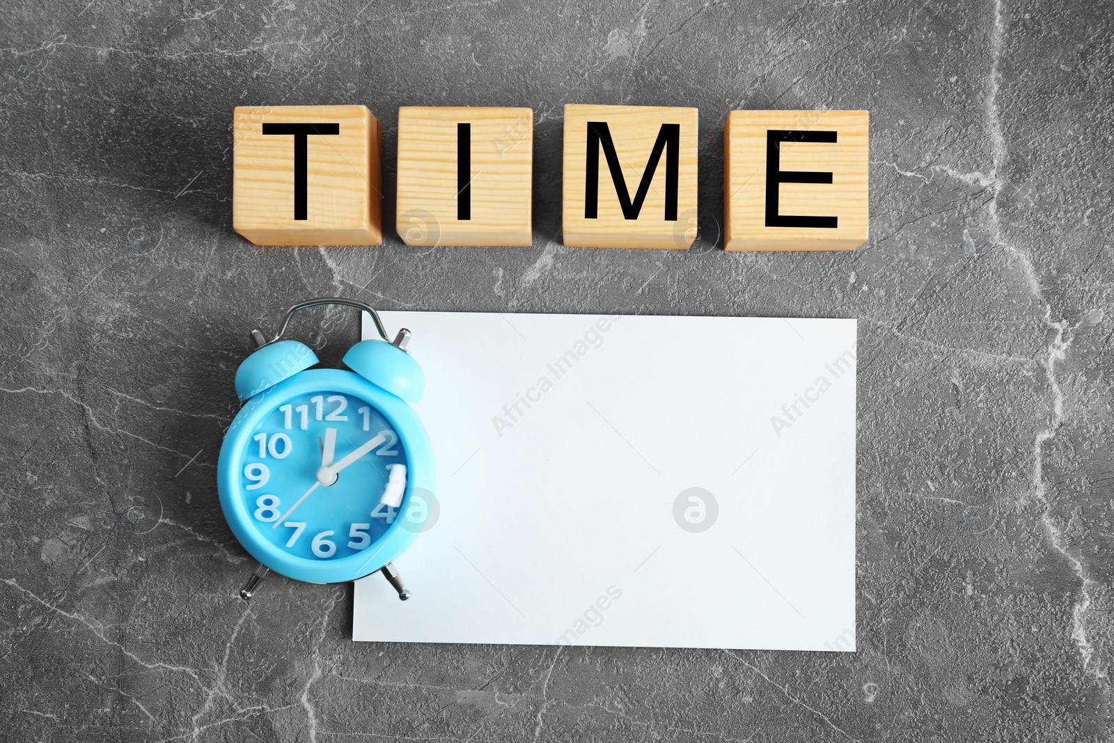 Photo of Cubes with text TIME, alarm clock and blank card on table