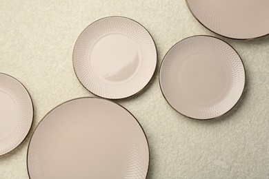 Beautiful ceramic plates on beige table, flat lay