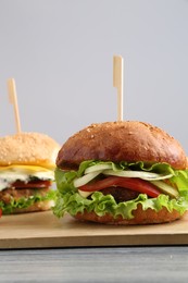 Delicious vegetarian burgers served on grey wooden table