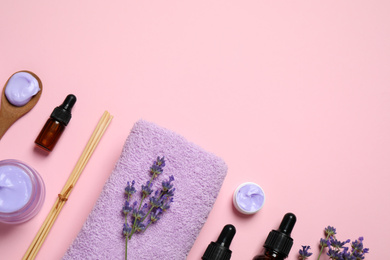 Photo of Cosmetic products and lavender flowers on pink background, flat lay. Space for text