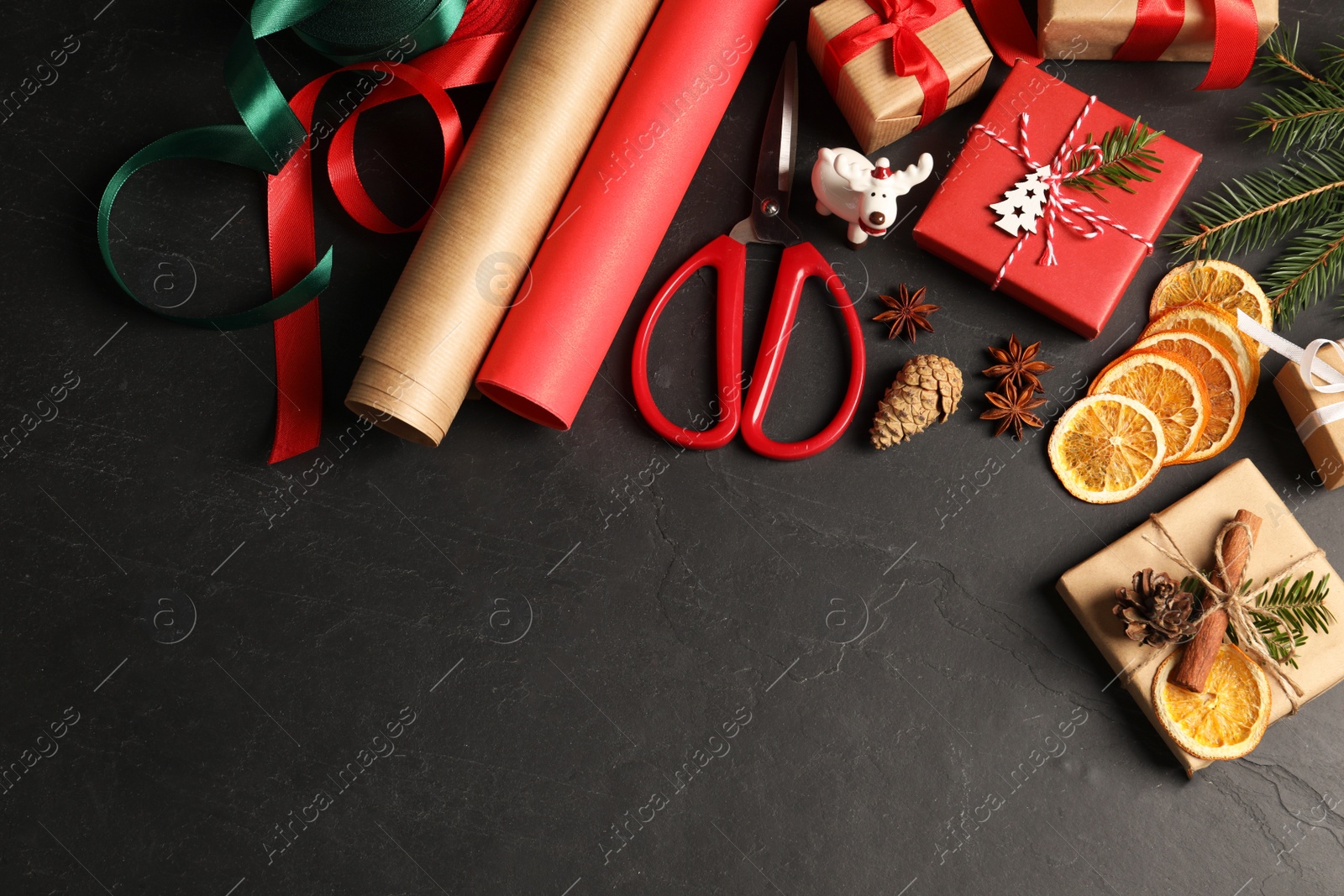 Photo of Flat lay composition with beautiful gift boxes and Christmas decorations on black table. Space for text