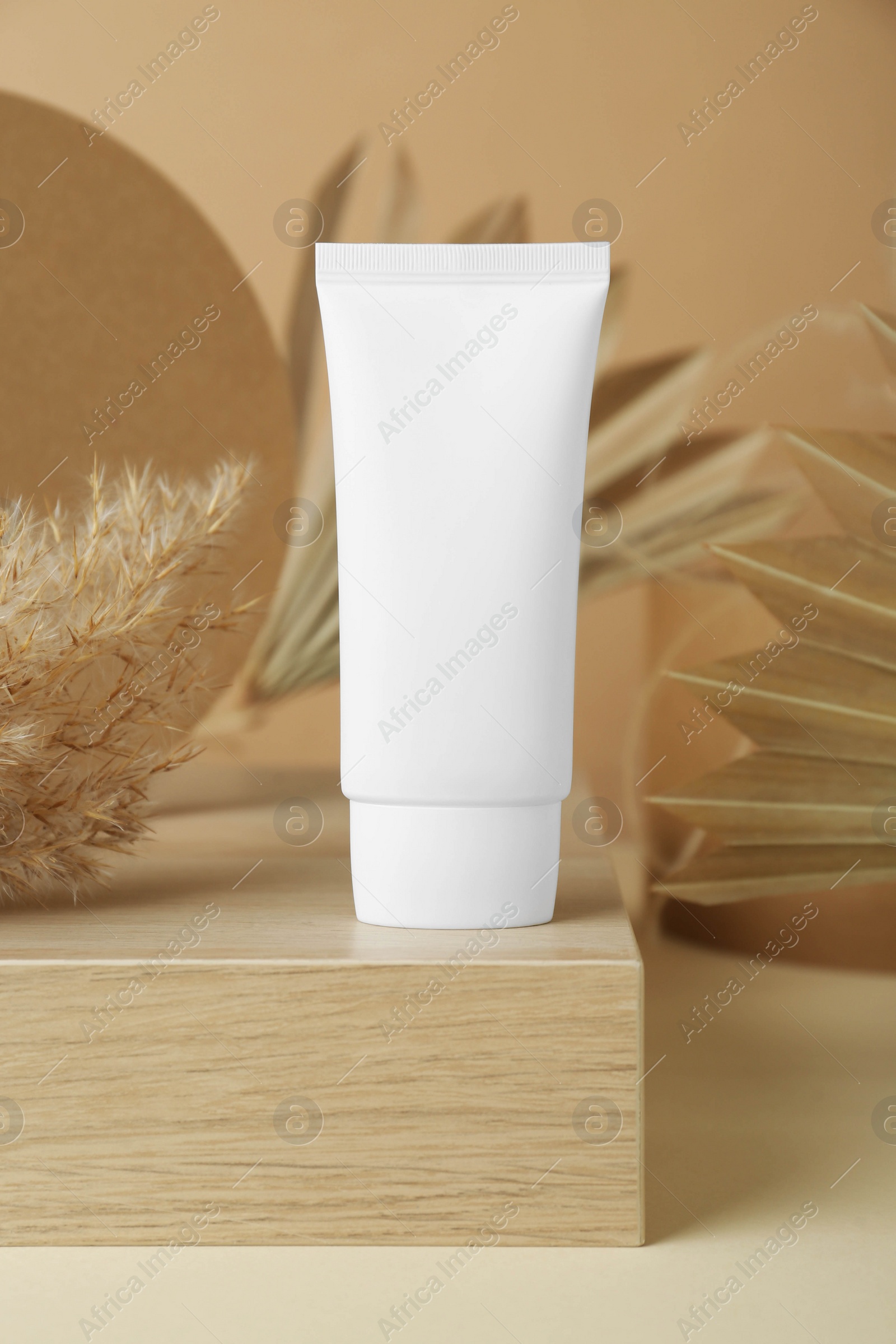 Photo of Composition with tube of hand cream on beige table