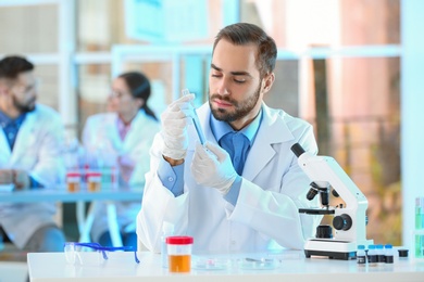 Photo of Young scientist working in laboratory. Chemical analysis