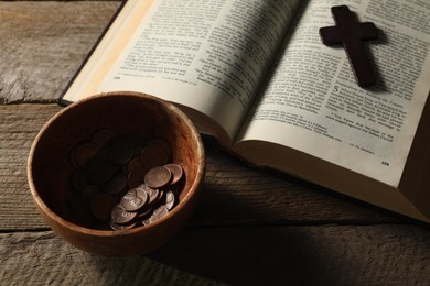 Photo of Donate and give concept. Coins in bowl, cross and Bible on wooden table