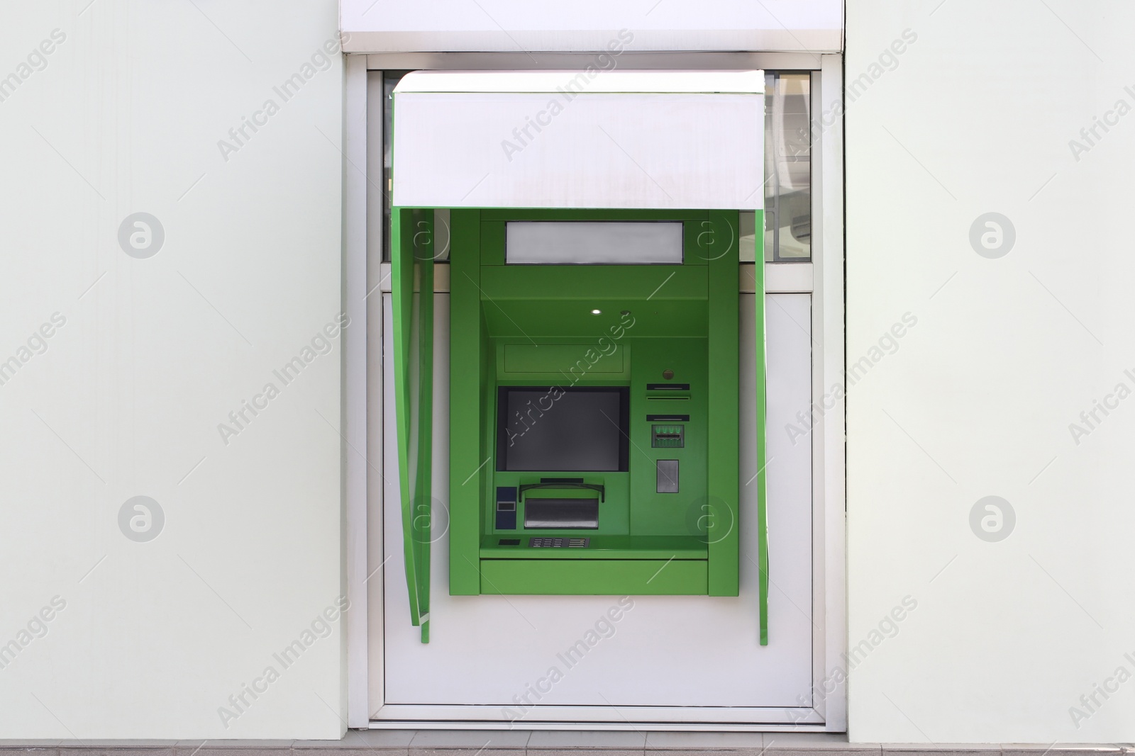 Photo of Modern automated cash machine with screen outdoors