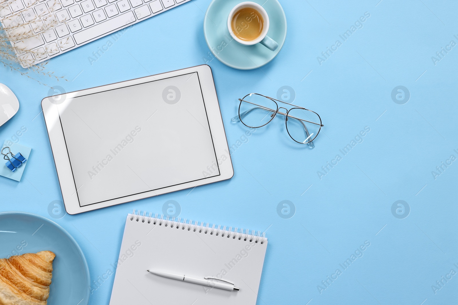 Photo of Flat lay composition with modern tablet on light blue background. Space for text