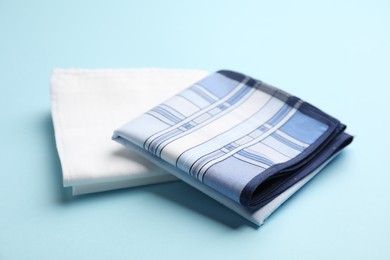 Photo of New stylish handkerchiefs on light blue background