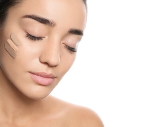 Young woman with different shades of skin foundation on her face against white background