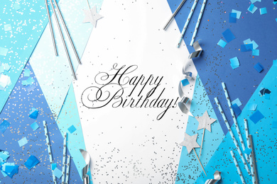 Flat lay composition with greeting HAPPY BIRTHDAY and party decor on color background