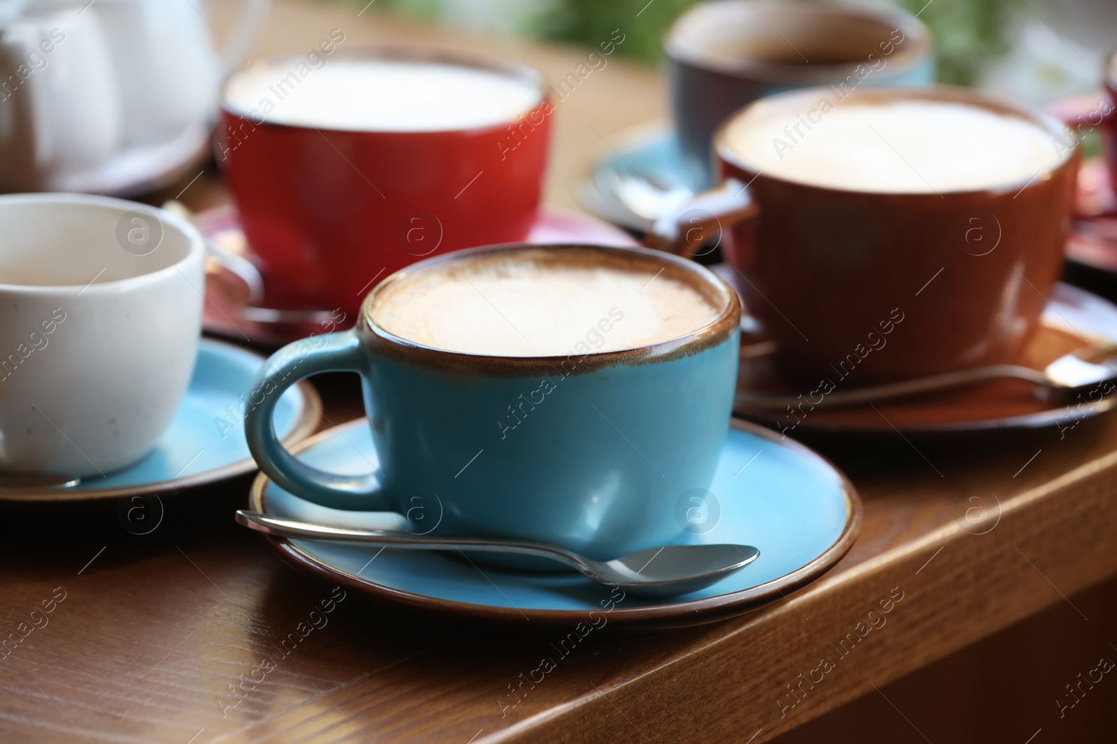 Photo of Cups of fresh aromatic coffee on wooden table