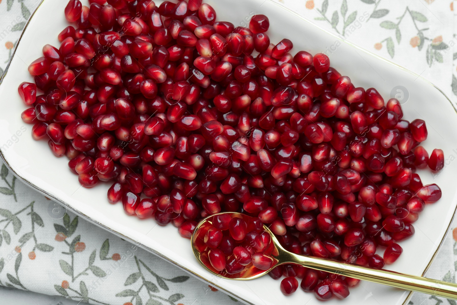 Photo of Ripe juicy pomegranate grains on white table, top view