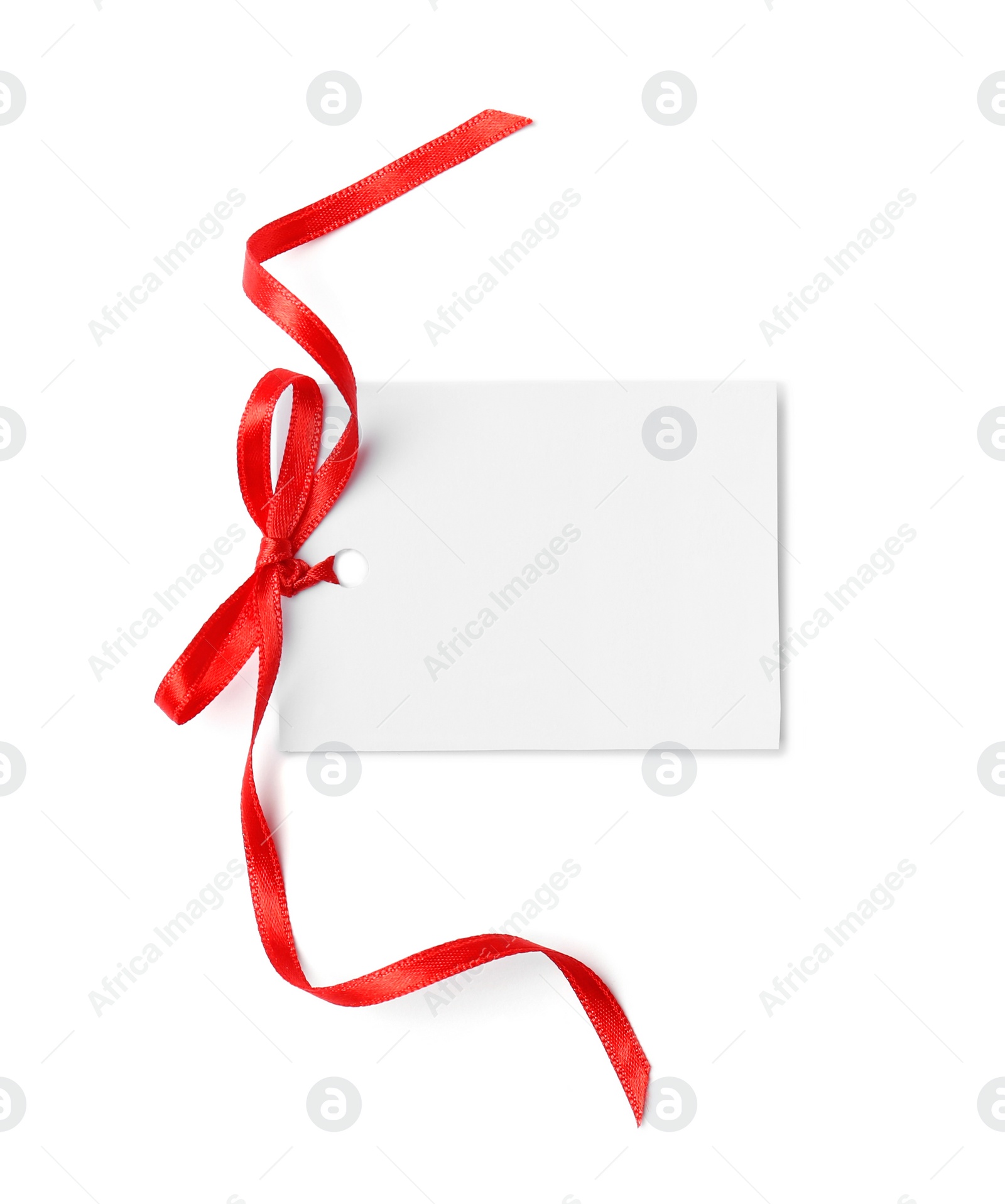 Photo of Blank gift tag with satin ribbon on white background, top view