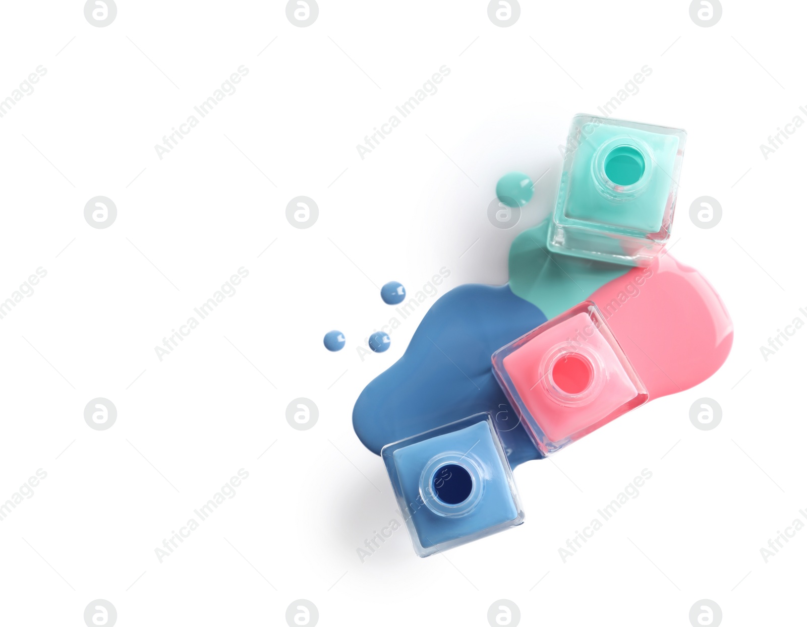 Photo of Spilled different nail polishes with bottles on white background, top view